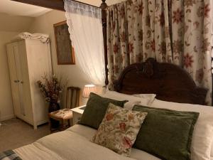 1 dormitorio con 1 cama con cabecero de madera en Drimnatorran Farm Lodge en Strontian
