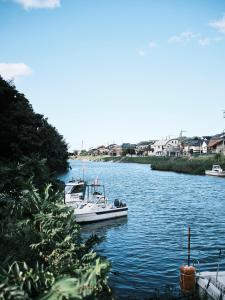 um pequeno barco está ancorado num rio em Aoyado - Tottori Aoya em Tottori