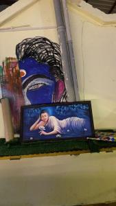 une télévision assise sur une étagère avec un tableau dans l'établissement Ganga Vardan hotel, à Rishikesh