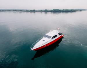 a red and white boat in the water at Private Yacht Bali to Nusa Penida in Ujung