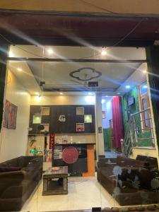 - un salon avec des canapés, une table et une cheminée dans l'établissement Ganga Vardan hotel, à Rishikesh