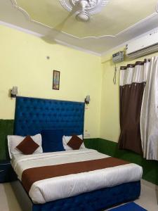 - un lit avec une tête de lit bleue dans l'établissement Ganga Vardan hotel, à Rishikesh