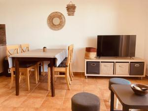 salon ze stołem i telewizorem w obiekcie Punta di Mare, appartements comme sur un bateau w mieście Linguizzetta