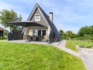 a house with an umbrella on a lawn at Holiday home Villa Maiwaldo in Spieka-Neufeld