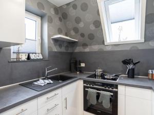 a kitchen with a sink and a stove at Holiday home Villa Maiwaldo in Spieka-Neufeld +13 photos