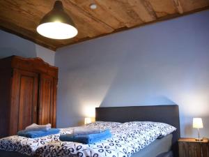 1 dormitorio con 1 cama con pared azul en Holiday home Deichkind on the Elbe dike, en Mödlich