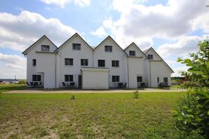 a large white building with four windows on a field at Apartment Hafenflair am Plauer See Plau am See in Plau am See