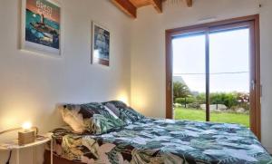 PlouarzelにあるBelle maison vue mer 5min de plageのベッドと大きな窓のある寝室