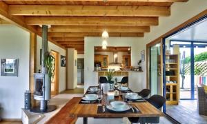comedor y cocina con mesa de madera en Belle maison vue mer 5min de plage en Plouarzel