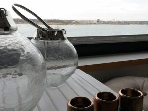 een glazen vaas op een tafel naast een raam bij Holiday house house on Mühlfeldsee in Löbnitz