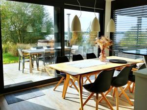 een eetkamer met tafels en stoelen en een groot raam bij Holiday house house on Mühlfeldsee in Löbnitz