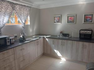 a kitchen with a counter top and a microwave at La Cordier in Kroonstad