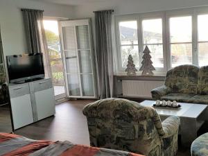 a living room with two chairs and a television at Holiday apartment Breit in Kirchdorf im Wald