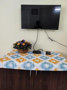 a table with a flower pot on top of a tv at 1 BHK Flat in Kochi 904 in Cochin