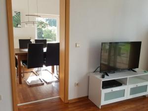 ein Wohnzimmer mit einem TV und einem Tisch mit Stühlen in der Unterkunft Holiday apartment Aufderhaar in Ostbevern
