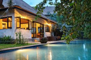 une maison avec une piscine en face d'une maison dans l'établissement Villa Ayung, à anur