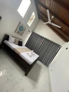 a bedroom with a bed with a ceiling fan at Jumelle Residence in Horetuduwa
