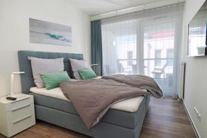a bedroom with a bed with a blue headboard at Apartment in Ostseeresort Olpenitz with balcony in Olpenitz