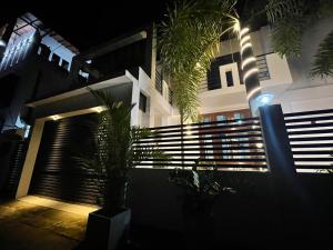a building at night with palm trees in front of it at Jumelle Residence in Horetuduwa