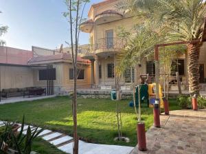 una casa con parque infantil frente a un patio en شاليه سهم, en Al Khobar