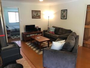 a living room with a couch and a table at The Sanctuary Stanthorpe in Amiens