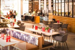ein Restaurant mit Tischen und Stühlen und eine Bar in der Unterkunft Apartments in the MAREM RITZ Yachthafen Resort Waren an der M ritz in Waren (Müritz)