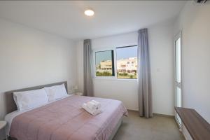 a bedroom with a bed with a towel on it at Eva Residences- Kapparis in Paralimni