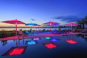 einen Pool mit Sonnenschirmen, Liegestühlen und Tischen in der Unterkunft Apartments in the MAREM RITZ Yachthafen Resort Waren an der M ritz in Waren (Müritz)