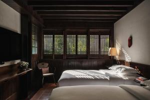 Un dormitorio con una cama grande y una ventana en Lijiang Ancient City Anyu Hotel, en Lijiang