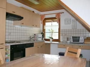 Il comprend une cuisine équipée d'un évier et d'une cuisinière. dans l'établissement Pleasant holiday home with balcony, à Seelgut