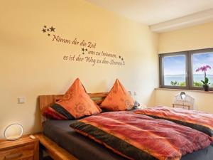 um quarto com uma cama com uma citação na parede em Mosel Sky Lounge with loggia & panoramic view em Kenn