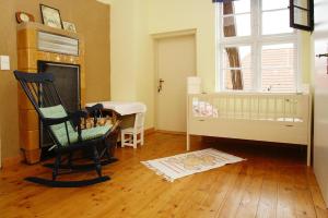 a room with a chair and a crib and a table at Apartment Plau am See in Plau am See