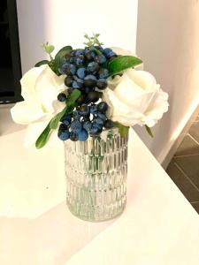 un vaso con mirtilli e fiori bianchi su un tavolo di HEART of Birmingham-City Centre a Birmingham