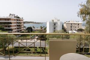 アテネにあるフォー シーズンズ ホテルの水辺と建物の景色を望むバルコニー