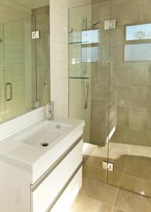 y baño con lavabo y ducha acristalada. en Apartments on Upton, en Wanaka