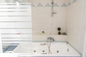 a bath tub with a shower in a bathroom at Four Seasons Hotel in Athens