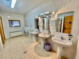 uma casa de banho com dois lavatórios e dois espelhos em Albergue Rural La Rueca, Fariza 