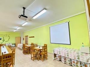 a restaurant with tables and chairs and a projection screen at Albergue Rural La Rueca, Fariza in Fariza