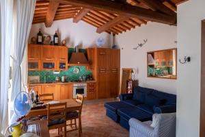 格雷韋伊恩基亞恩蒂的住宿－Casa le Capanne，客厅配有蓝色的沙发和桌子