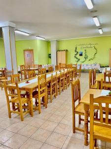 uma sala de jantar com mesas e cadeiras de madeira em Albergue Rural La Rueca, Fariza 