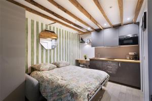 a bedroom with a bed and a kitchen at Charmant studio tout confort in Paris