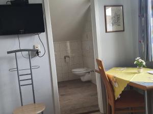 ein Badezimmer mit einem Tisch, einem WC und einem TV in der Unterkunft Large detached holiday home in Hesse with private garden and terrace in Homberg