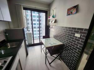 Una pequeña cocina con una mesa y una ventana. en 芭提雅双人精品公寓无边游泳池THEBASE中央基地, en Pattaya central