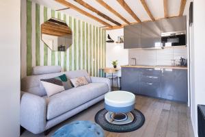 a living room with a couch and a kitchen at Charmant studio tout confort in Paris