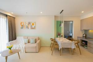 a kitchen and a living room with a table and a couch at The Song Apartment - CONDOTEL BUNNY HOME VUNG TAU in Vung Tau