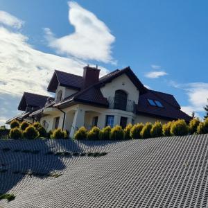 a house with a roof on top of a driveway at Windmill Resort Agroturystyka in Mucharz