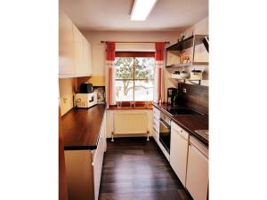 a kitchen with white cabinets and a window at Crystal holiday home in Sankt Englmar