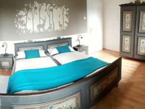 ein Schlafzimmer mit einem großen Bett mit blauer Bettwäsche in der Unterkunft Crystal holiday home in Sankt Englmar