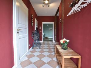 a hallway with red walls and a table with flowers on it at Historic Apartment in Gerdshagen with Garden in Gerdshagen