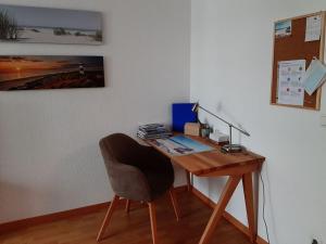 a wooden desk with a chair next to a wall at Holiday apartment Central in Rostock